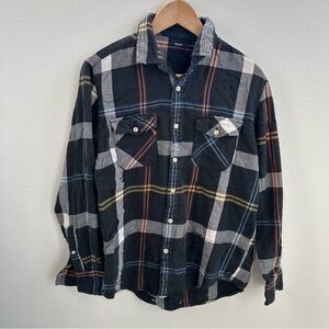 Black and grey plaid flannel shirt with a distressed look